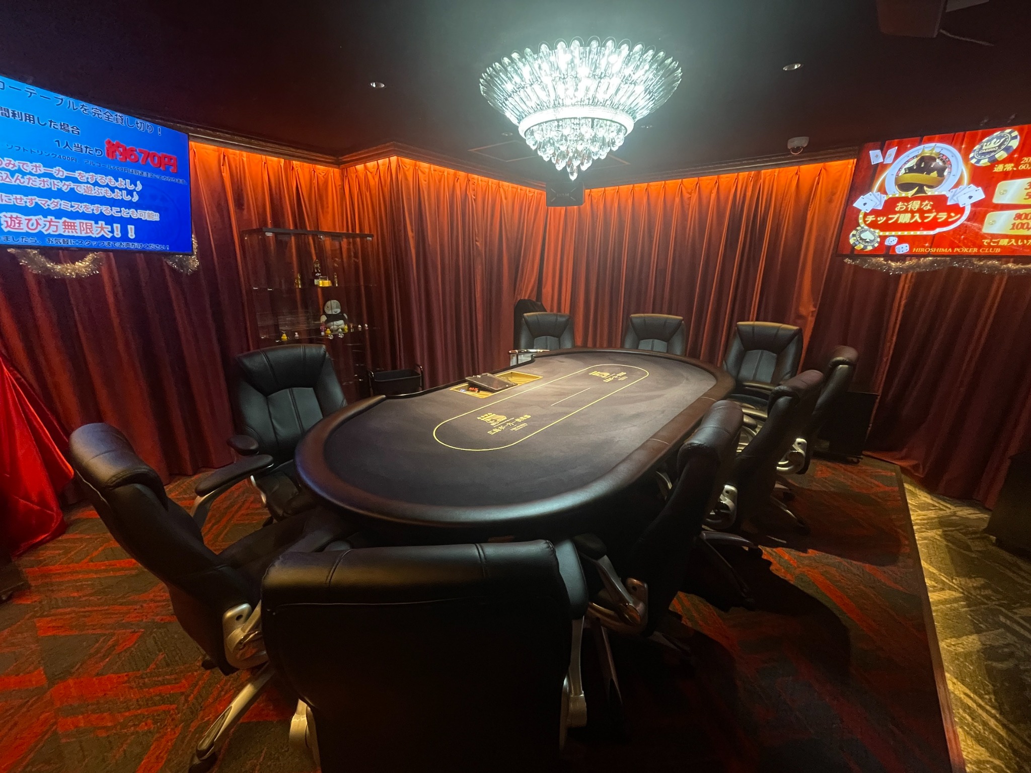 シャンデリアと赤いカーテンに囲まれた広島ポーカー倶楽部のポーカーテーブル